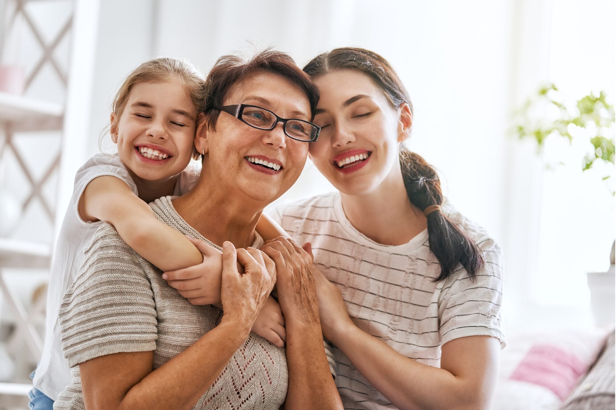 A grandmother, mother and daughter laughing together