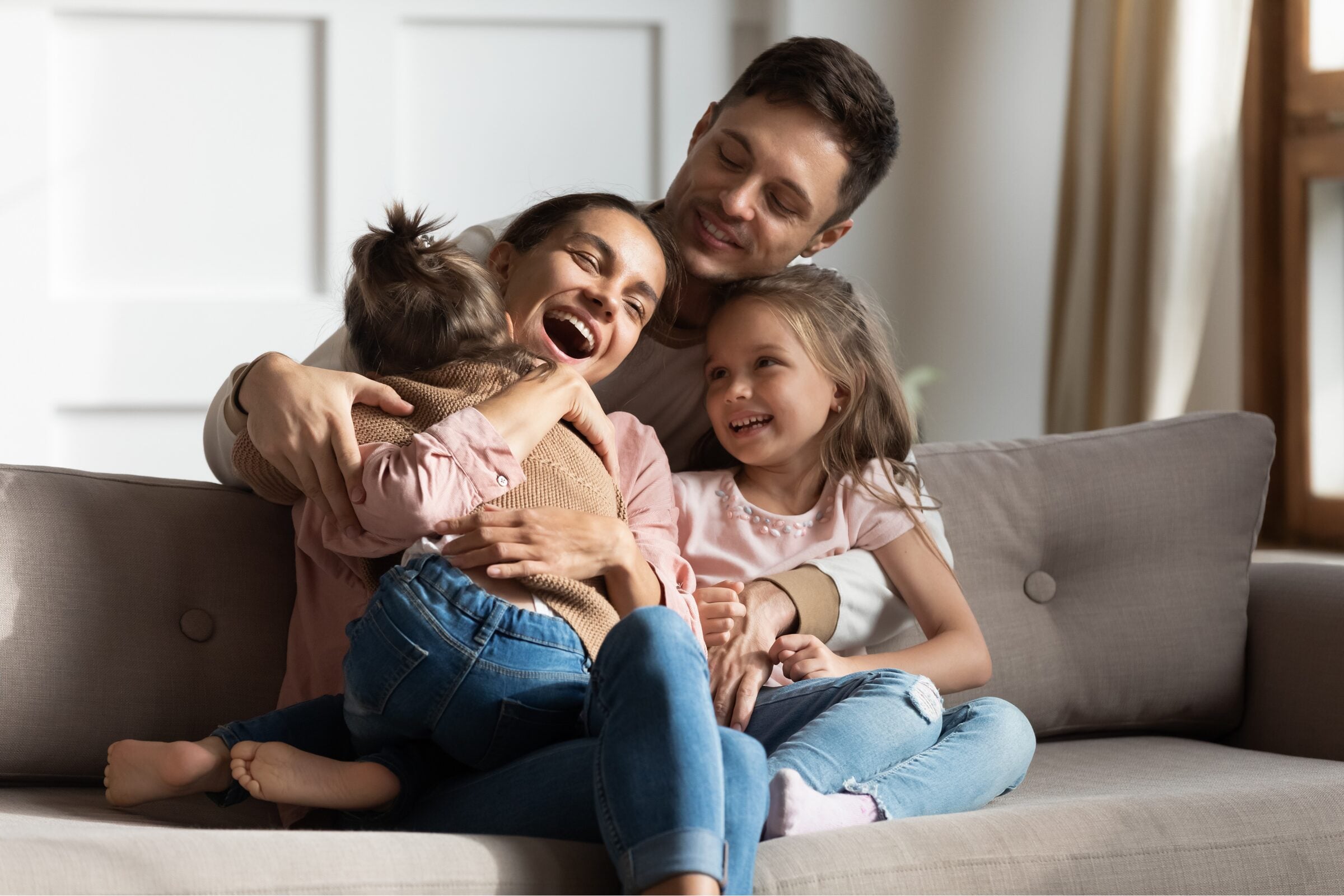 A family relaxing together on a sofa at home